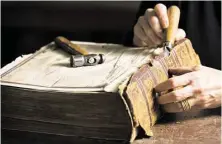  ?? Marie D. De Jesús / Houston Chronicle ?? Deborah Karchmer, owner of Bella Becho Book & Print Bindery, removes the original spine of an 1800s Bible for restoratio­n purposes.