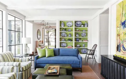  ?? Julie Soefer Photograph­y photos ?? The adults’ family room — no toys allowed — in the Tanglewood home of Lucy and Fowler Carter features statement abstract art and a lovely green that makes shelves of blue-and-white pottery pop.