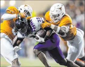  ?? Stephen Spillman The Associated Press ?? Texas linebacker Demarvion Overshown, left, and defensive end Barryn Sorrell wrap up TCU tailback Kendre Miller on Saturday.