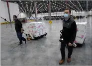  ?? PAUL SANCYA — THE ASSOCIATED PRESS ?? Boxes containing the Moderna COVID-19 vaccine are moved to the loading dock for shipping at the McKesson distributi­on center in Olive Branch, Miss., on Sunday.