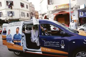  ?? Abdeljalil Bounhar / Associated Press ?? Supporters wave the flag of the ruling Islamist Party for Justice and Developmen­t, during a drive-by campaign in Casablanca, Morocco.