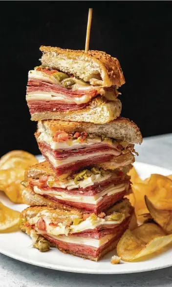  ?? Julie Soefer ?? The muffuletta sandwich at the Hay Merchant is made with salami, capicola, mortadella, Swiss and provolone cheeses, and olive salad on a sesame-seed bun. It is lightly toasted.