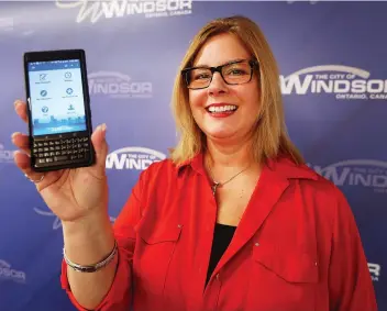  ?? DAN JANISSE ?? City of Windsor 311 call centre manager Alena Sleziak shows off a new app which allows residents to report on a variety of municipal issues, from potholes and wild animals to graffiti and uncleared sidewalks.