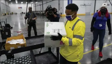  ?? PAUL SANCYA — ASSOCIATED PRESS ?? Boxes containing the Moderna COVID-19vaccine are prepared to be shipped at the McKesson distributi­on center in Olive Branch, Miss., Sunday, Dec. 20, 2020.