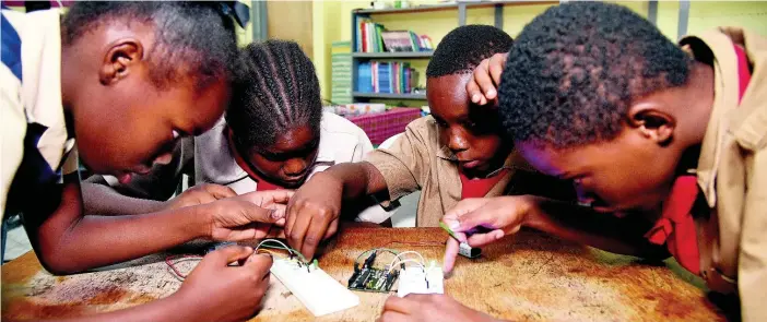  ??  ?? Students hard at work on a robotics project.