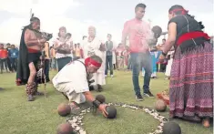  ??  ?? Participan­tes realizan un ritual para bendecir las pelotas de hule.