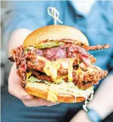  ?? SPECIAL TO TORSTAR ?? Matty Cipollo holds The Big Matt, a fried chicken sandwich dressed with pimento cheese, smokey bacon, Matty’s sauce, house pickles and iceberg lettuce.