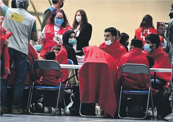  ?? EPA ?? Afghan migrants receive attention from Red Cross personnel after arriving at the Torrejon de Ardoz military air base in Madrid