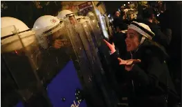  ?? PHOTOS BY KHALIL HAMRA — THE ASSOCIATED PRESS ?? A protester argues with anti-riot policemen at the end of the gathering to mark Internatio­nal Women's Day in Istanbul, Turkey, on Wednesday.