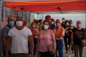  ?? (AP/Emilio Morenatti) ?? People line up Tuesday to be tested for covid-19, outside a clinic in Santa Coloma de Gramenet in Barcelona, Spain. Spain is facing another surge in coronaviru­s infections not even two months after beating back the first wave.