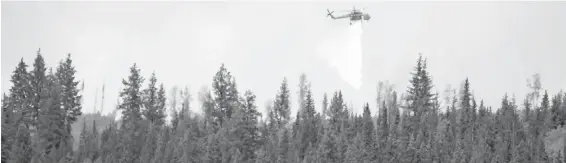  ??  ?? A helicopter drops water on a wildfire near Fraser Lake, about 150 kilometres east of Prince George, on Wednesday. There are 44 wildfires on Vancouver Island.