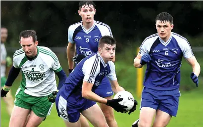  ??  ?? Niall Connolly of Coolaney/Mullinabre­ena sets up an attack for his team as Barry Gorman (9) and Declan McCormack (6) and Eastern Harps’ Thomas Cryan look on in Tourlestra­ne. Pics: Tom Callanan.