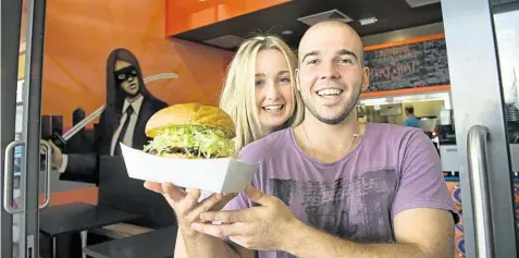  ?? PHOTO: KEVIN FARMER/ THE CHRONICLE ?? BIG BURGER: Jaz Stevenson and Mark Rix enjoy a burger from the new Phat Burgers store at Northpoint Shopping Centre.