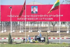  ?? AFP ?? Motorcycle mounted police ride pass a billboard welcoming the visit of Chinese President Xi Jinping in Naypyidaw yesterday.