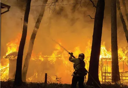  ?? FOTO EFE ?? Un bombero intenta contener las llamas de Camp Fire en la ciudad de Butte County, California. Además de los vientos, las líneas eléctricas han contribuid­o a la propagació­n del fuego.