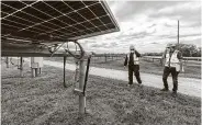  ?? William Luther / Staff file photo ?? OCI Solar Power's Rico Zuniga, left, and Timothy Heinle tour the Alamo 1 Solar Farm in San Antonio.