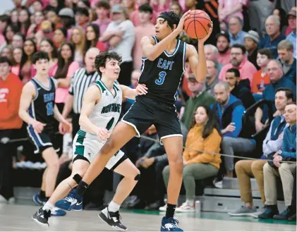  ?? HARTFORD COURANT ?? East Catholic’s Matt Morgan, right, tries to keep the ball away from Northwest Catholic’s Gianni Mirabello during the teams’ regular-season meeting on Feb. 14. Morgan and the Eagles handed the Lions a 70-49 defeat then, but there could be another meeting in the future as East was named the top seed in the state Division I tournament with Northwest ranked No. 2 in the field.