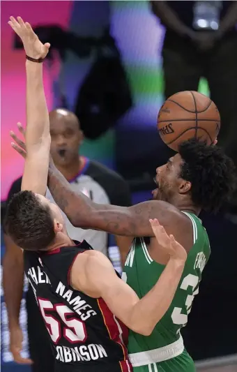  ?? Ap pHOTOS ?? TOUGH DAY: Heat guard Duncan Robinson defends a shot by Celtics guard Marcus Smart during the first half of Game 4 of the Eastern Conference finals on Wednesday night in Lake Buena Vista, Fla. At left, Celtics coach Brad Stevens gestures as he talks with Kemba Walker (left) and Jaylen Brown during a timeout in the first half.