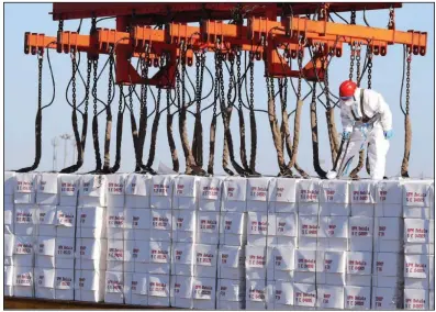  ?? (AP/Chinatopix) ?? A worker handles goods Tuesday at the container port in Qingdao in east China’s Shandong province. An array of imported products made in China’s Xinjiang region were banned Wednesday in an overwhelmi­ng vote in the House.