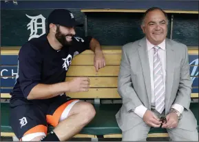  ?? Associated Press ?? Father and Son: Detroit Tigers' Alex Avila, left, shares a laugh with his father, general manager Al Avila during an interview in the dugout in Detroit. Al strives to strike a balance between business and personal with his son, Alex, who plays catcher...