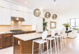  ??  ?? The kitchen at 1171 Stanyan St. offers a 36-inch Bertazzoni range, pendant lights and cabinetry with natural walnut and white matte finishes. The condo is listed for $3.5 million.