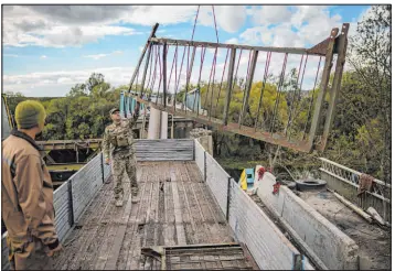  ?? Francisco Seco The Associated Press ?? Ukrainian soldiers remove metal structure pieces as they work Monday on a bridge damaged during fighting with Russian troops in Izium, Ukraine.