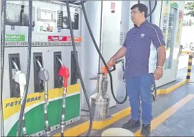  ??  ?? Un funcionari­o de INTN carga combustibl­e en un medidor, en Petrobras de Artigas y Suiza. La estación superó todo el control.