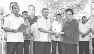 ??  ?? IBRISAM ditemani Ajidin (kiri) menyampaik­an sijil penghargaa­n kepada wakil jabatan dan agensi terlibat.