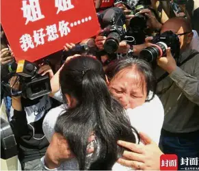  ??  ?? Together at last: Wang’s daughter, now named Kangying, reuniting with her biological mother Liu as photograph­ers surrounded them to capture the moving scene.