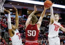  ?? JAY LAPRETE / AP ?? Indiana’s Joey Brunk (center) shoots between Ohio State’s Kaleb Wesson (left) and Justin Ahrens in 2020. Brunk played two seasons each at Indiana and Butler, where he was recruited by then-Bulldogs coach Chris Holtmann.