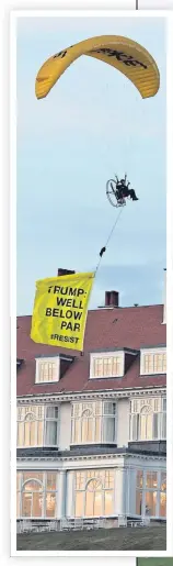  ??  ?? A paraglider trails a banner over Turnberry as Donald Trump, circled right, arrives