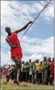  ?? ?? A Maasai man throws a javelin Dec. 10 as he competes in the Maasai Olympics.