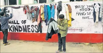  ?? WASEEM ANDRABI/HT ?? ■ A needy man picking a jacket donated by people at the 'The Wall of Kindness' in uptown Srinagar on Wednesday.