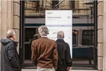  ?? Francesca Volpi/Bloomberg ?? People view stock informatio­n in the UBS headquarte­rs window Friday in Zurich, Switzerlan­d. UBS bid 3 billion francs to buy Credit Suisse.