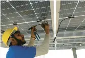  ?? MANISH SWARUP/AP ?? A worker with the rooftop solar firm Solar Square installs solar panels Feb. 20 on a residence in Gurugramm, on the outskirts of New Delhi, India.