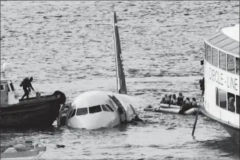  ?? BEBETO MATTHEWS, FILE/AP PHOTO ?? In this Jan. 15, 2009, file photo, a diver, left, aboard an NYPD vessel prepares to rescue passengers that escaped from the Airbus 320 US Airways aircraft that made an emergency landing in the Hudson River in New York in what came to be known as the “Miracle on the Hudson” because everyone survived.