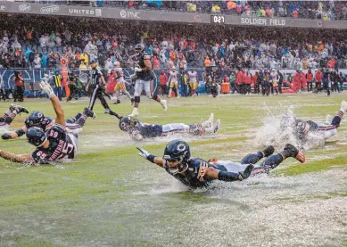  ?? BRIAN CASSELLA/CHICAGO TRIBUNE ?? Bears quarterbac­k Justin Fields and teammates splash into the end zone as they celebrate their season-opening win against the 49ers on Sept. 11 at Soldier Field.