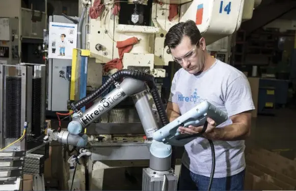  ?? ACKERMAN + GRUBER FOR THE WASHINGTON POST ?? Rob Goldiez, co-founder of Hirebotics, configures a robot at Tenere Inc. in Dresser, Wis.