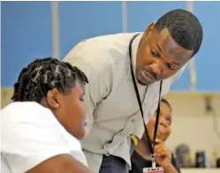  ?? ?? Timothy Allison works with a student at Sun Valley Elementary School on Sept. 8 in Birmingham, Ala.