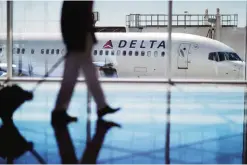  ??  ?? ATLANTA: A Delta Air Lines jet sits at a gate at Hartsfield-Jackson Atlanta Internatio­nal Airport in Atlanta. Delta announced that the airline is rolling out new free snacks for customers in the main cabin, including brand-name yogurt bars and...