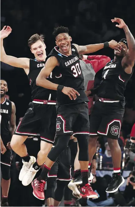  ?? JULIO CORTEZ/THE ASSOCIATED PRESS ?? South Carolina players celebrate after beating Baylor 70-50 in their East Regional semifinal game of the NCAA men’s college basketball tournament Friday in New York.