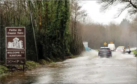 ??  ?? Drivers struggling to get through flood waters at Ballymaqui­rk Cross near Kanturk on Tuesday. Photo by Sheila Fitzgerald