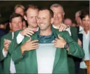  ?? DAVID J. PHILLIP - THE ASSOCIATED PRESS ?? 2016 champion Danny Willett puts the green jacket on Sergio Garcia after Garcia won the Masters golf tournament Sunday in Augusta, Ga.