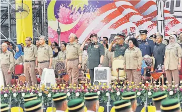  ??  ?? Sultan Muhammad V (front row, second right) gives the royal salute to the marching contingent­s as (from third left, front row) Zahid, Najib, Rosmah and other cabinet ministers look on. — Bernama photo