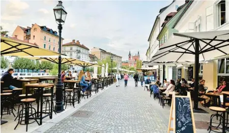  ?? CAMERON HEWITT ?? Ljubljana’s riverfront promenade is lined with quaint boutiques, great restaurant­s and cafés.