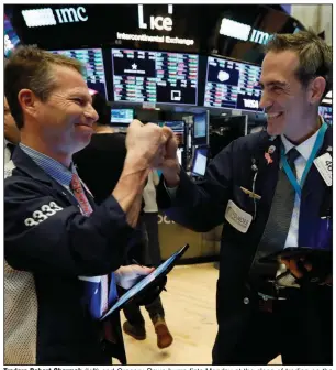  ?? (AP/Richard Drew) ?? Traders Robert Charmak (left) and Gregory Rowe bump fists Monday at the close of trading on the floor of the New York Stock Exchange, celebratin­g the stock market’s rebound after more than a week of heavy losses. More photos at arkansason­line.com/33market/.