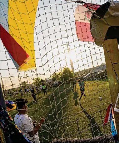  ?? Yi-Chin Lee / Houston Chronicle ?? Un futbolista aficionado practica remates frente a una portería ubicada delante de una reja de la que cuelgan banderas de países latinoamer­iocanos en la liga de ‘La Pulga Loca’ en el sudoeste de Houston.