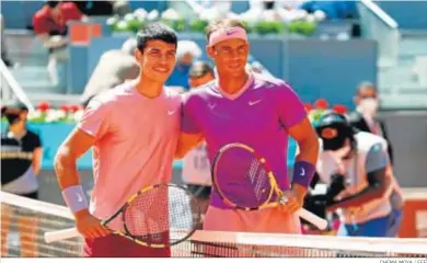  ?? CHEMA MOYA / EFE ?? Carlos Alcaraz y Rafael Nadal se saludan antes del encuentro de dieciseisa­vos de final del Masters 1.000 de Madrid.