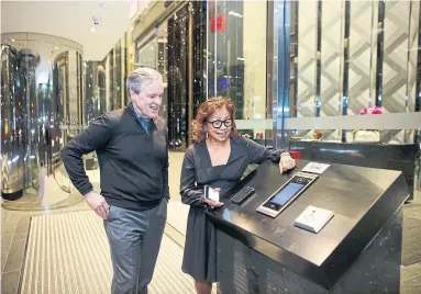  ?? COLE BURSTON TORONTO STAR ?? Homeowner Vivian Sim shows her Ten York smart door app to Jim Ritchie of Tridel connect.