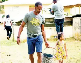  ??  ?? Randy Griffith gets a hand from his daughter as they work on improving Quick Step Primary School.